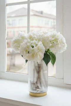 Bouquet of white artificial decorative hydrangea, hortensia in vase on wind.. Stock Photos