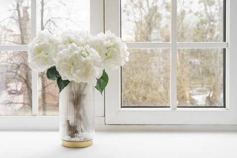 Bouquet of white artificial decorative hydrangea, hortensia in vase on wind.. Stock Photos