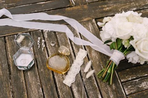 A bouquet of white roses with a long developing ribbon, an openwork garter, a Stock Photos