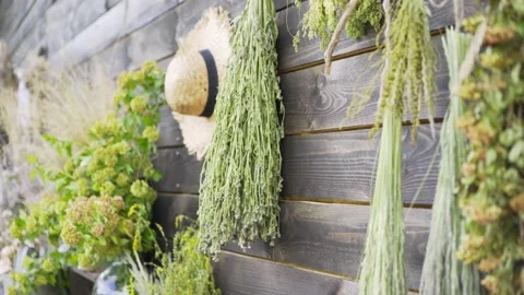Bouquets on aromatic wildflowers hang on rustic wooden wall Stock-Footage 136654286