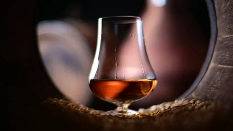 Bourbon whiskey trickles down the surface of a glass Video stock 269022323