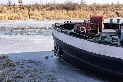 The bow of a barge on an ice-bound river. Rigging on the deck of the vessel. Stock Photos