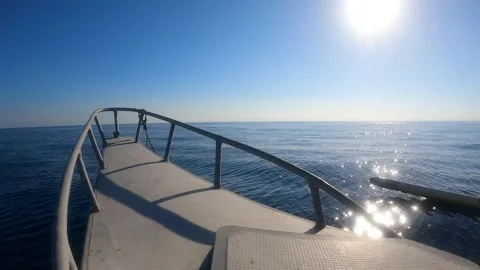 Bow of a boat cutting through the water with the sun reflects on it Stock Footage 159936320