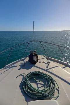 Bow of a boat with while sailing in the ocean with nautical mooring rope. cle Stock Photos