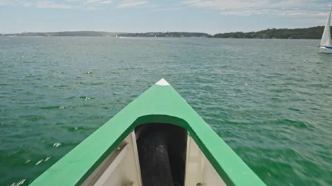 The bow of a ferry cuts through Sydney Harbour waters, with distant shoreline Stock-Footage 307276601