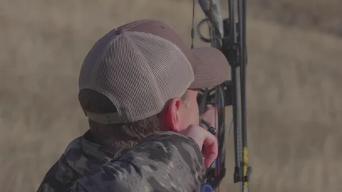 Bow Hunter Aims and Draws Arrow toward target deer Stock Footage 123400140