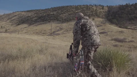 Bow Hunter crouches sneaking quitely toward target of deer Stock Footage 123402802