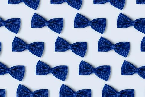 Bow ties repetitive pattern on a blue pastel background. Stock Photos