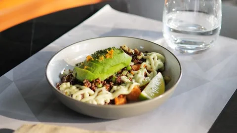 Bowl with avocado sits on restaurant table ready Stock Footage 282716847