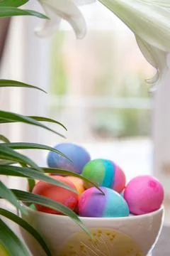 Bowl of brightly colored Easter eggs on diplay in kitchen window Stock Photos