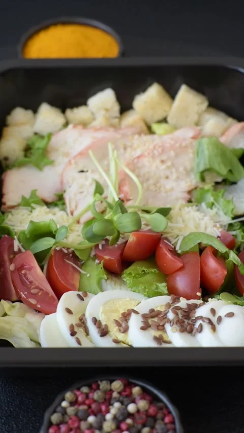 Bowl with caesar salad with chicken, parmesan cheese, tomatoes, croutons, lettuc Stock Footage 308531373