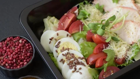 Bowl with caesar salad with chicken, parmesan cheese, tomatoes, croutons, lettuc Stock Footage 308531382