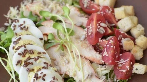 Bowl with caesar salad with chicken, parmesan cheese, tomatoes, croutons, lettuc Stock Footage 308531383