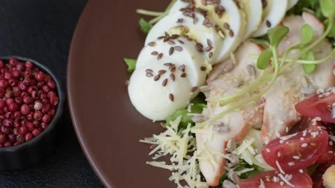 Bowl with caesar salad with chicken, parmesan cheese, tomatoes, croutons, lettuc Stock Footage 308531390