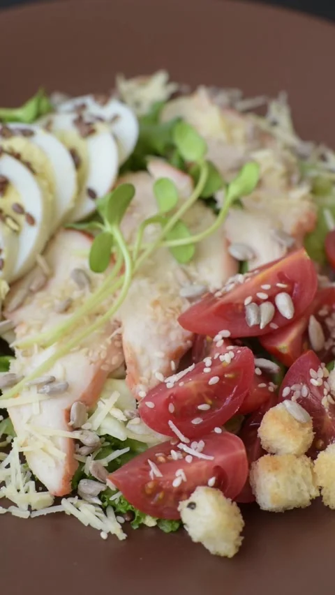 Bowl with caesar salad with chicken, parmesan cheese, tomatoes, croutons, lettuc Stock Footage 308531391