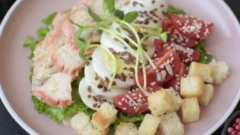 Bowl with caesar salad with chicken, parmesan cheese, tomatoes, croutons, lettuc Stock Footage 308531397