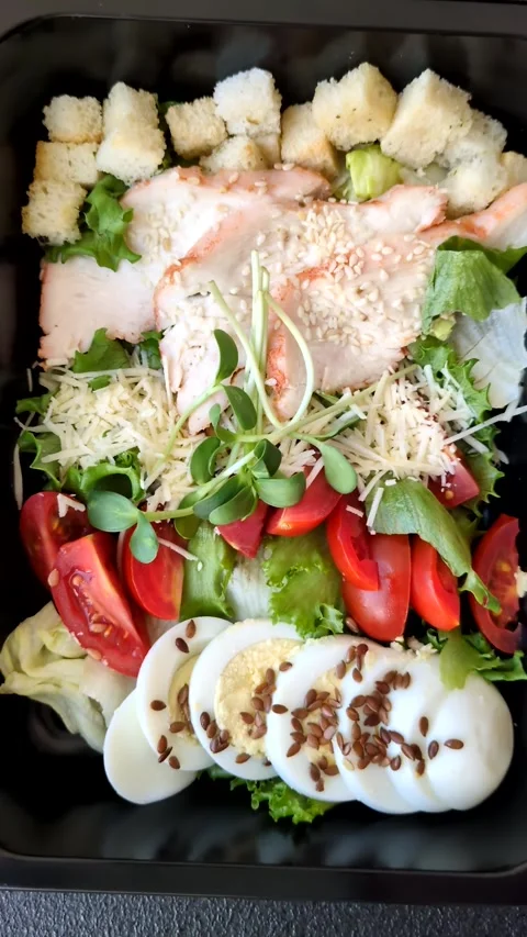 Bowl with caesar salad with chicken, parmesan cheese, tomatoes, croutons, lettuc Stock Footage 308531459