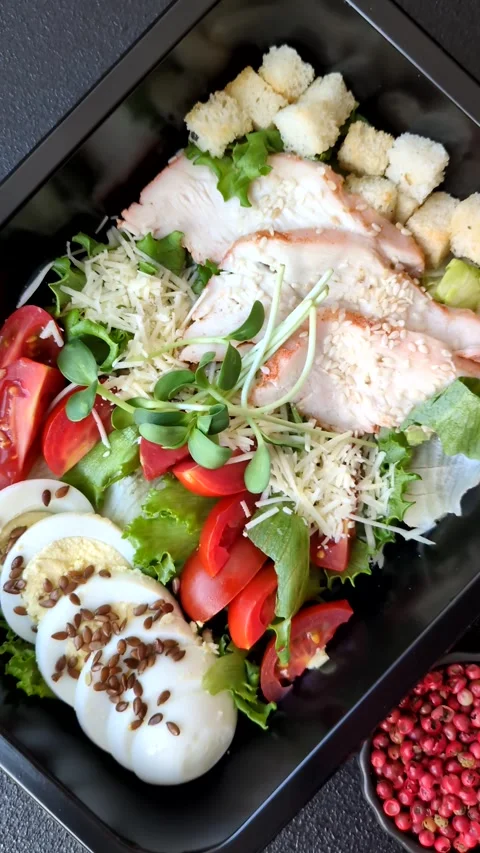 Bowl with caesar salad with chicken, parmesan cheese, tomatoes, croutons, lettuc Stock Footage 308531462