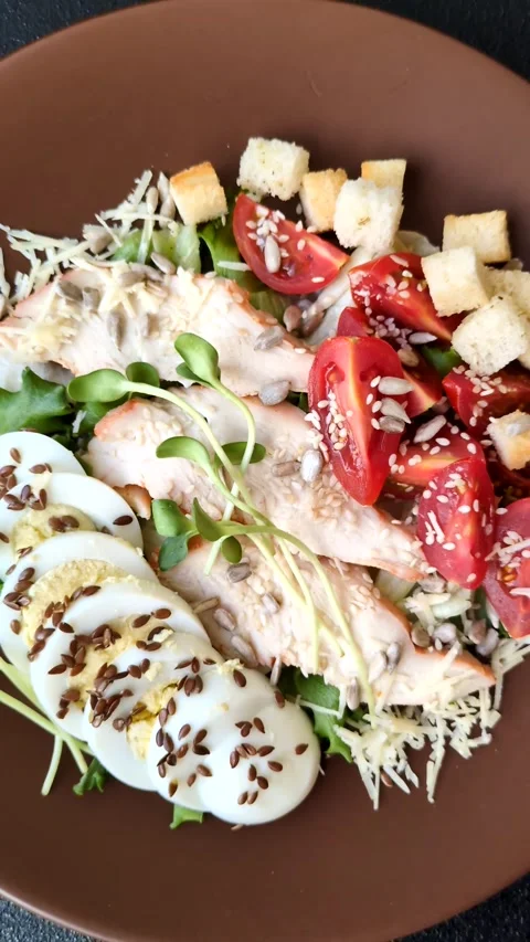 Bowl with caesar salad with chicken, parmesan cheese, tomatoes, croutons, lettuc Stock Footage 308531467