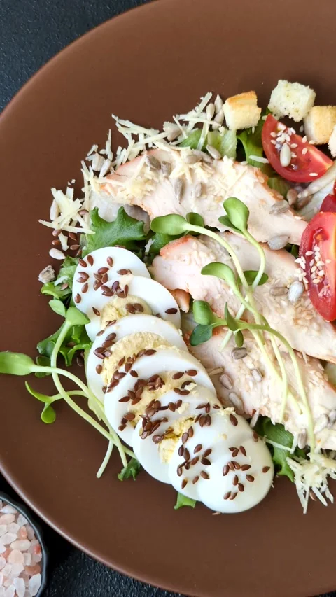 Bowl with caesar salad with chicken, parmesan cheese, tomatoes, croutons, lettuc Stock Footage 308531470