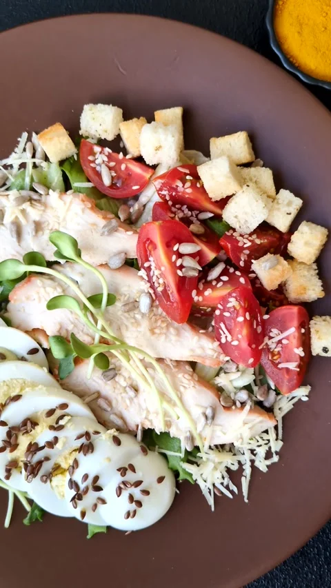 Bowl with caesar salad with chicken, parmesan cheese, tomatoes, croutons, lettuc Stock Footage 308531472