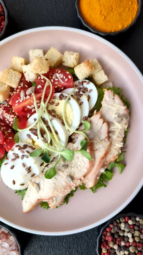 Bowl with caesar salad with chicken, parmesan cheese, tomatoes, croutons, lettuc Stock Footage 308531481