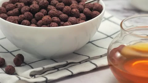 Bowl of chocolate corn balls breakfast on table with glass of milk Stock Footage 325536961