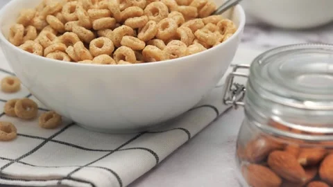Bowl of corn rings breakfast on table with glass of milk, fruits and nuts Stock Footage 327817144