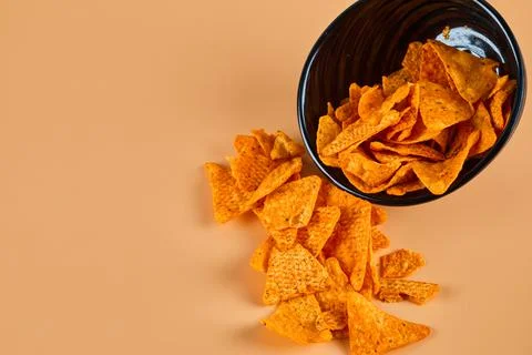 Bowl of crispy chips on orange background Stock Photos
