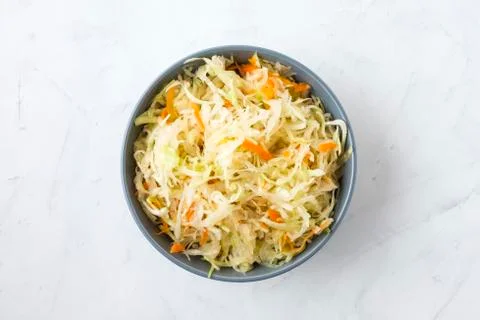 Bowl of fermented cabbage on plaster surface Stock Photos