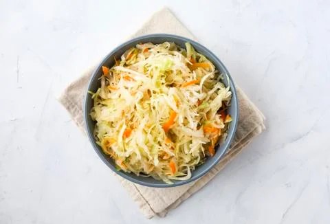 Bowl of fermented cabbage on plaster surface Stock Photos