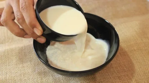 A bowl of flour plus liquid milk. someone makes flour dough Stock-Footage 334647045