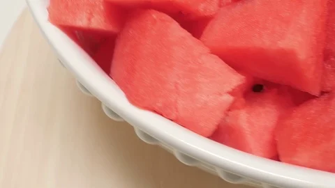 Bowl of Fresh Watermelon Chunks Spin on a Wooden Turntable Stock Footage 79384490