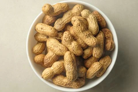 Bowl of freshly harvested peanuts lying on a rustic kitchen table Foto stock