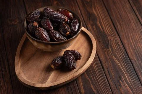 Bowl full of delicious dates elegantly presented on wooden surface, natural.. Fotos Stock