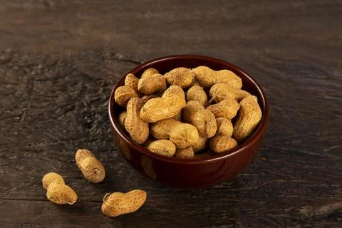 Bowl full of roasted peanuts. Stock Photos