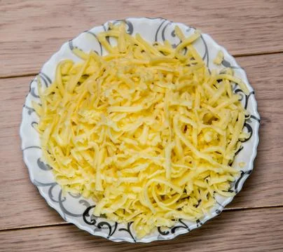 Bowl of grated cheese on wooden table background Stock Photos