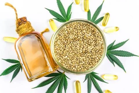Bowl with Hemp seeds Cannabis leafs and CBD oil capsules isolated on white Stock Photos
