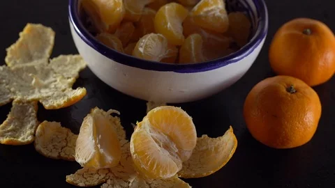 A bowl of mandarins on a black table. Видео 70078598