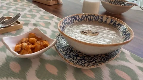 Bowl of mushroom soup with croutons on patterned tablecloth on wooden table.. Stock Footage 331031201