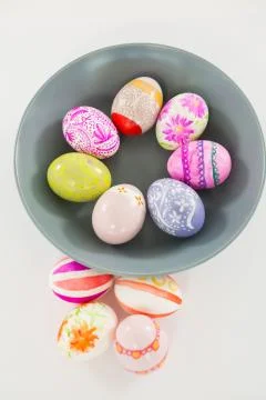 Bowl with painted Easter eggs on white background 库存照片
