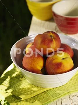 Bowl of Peaches on Folded Green Dish Towel Stock Photos