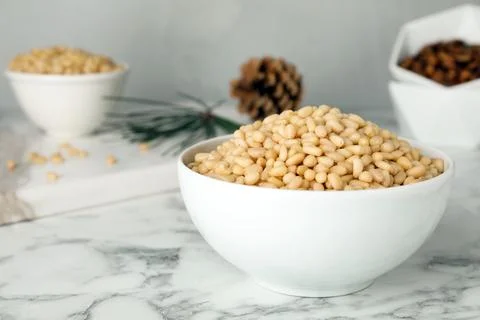 Bowl with pine nuts on marble table. Space for text Foto stock