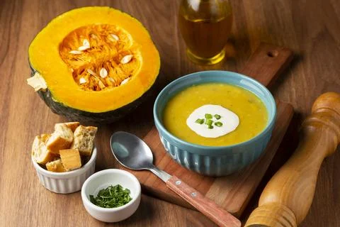 Bowl with pumpkin soup on the table. Stock Photos