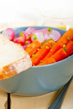 Bowl of steamed root vegetable on a rustic white wood table Foto stock