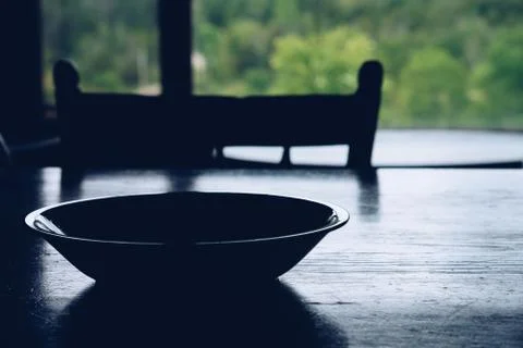 Bowl on table in front of forest window Stock Photos