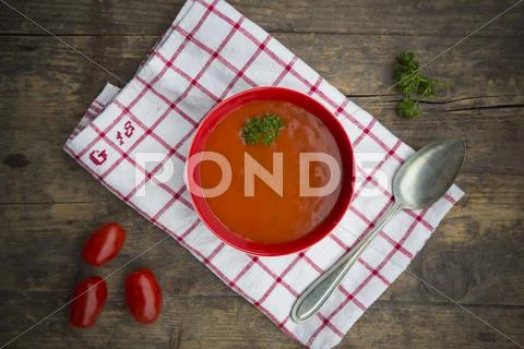Bowl Of Tomato Soup On Kitchen Towel And Wooden Table