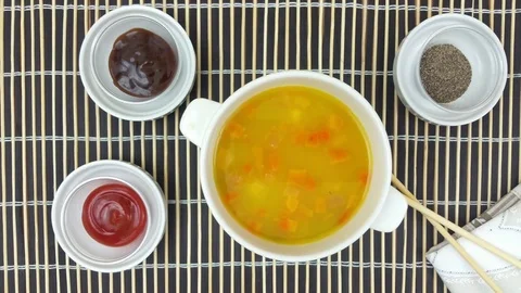 Bowl of vegetable soup rotating on a bamboo table mat Stock Footage 78077443