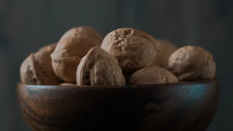 A bowl of walnuts revolves on a dark background. Close-up. Stock Footage 119776395