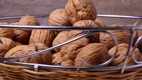 A bowl of walnuts rotate on a board Stock Footage 248323013